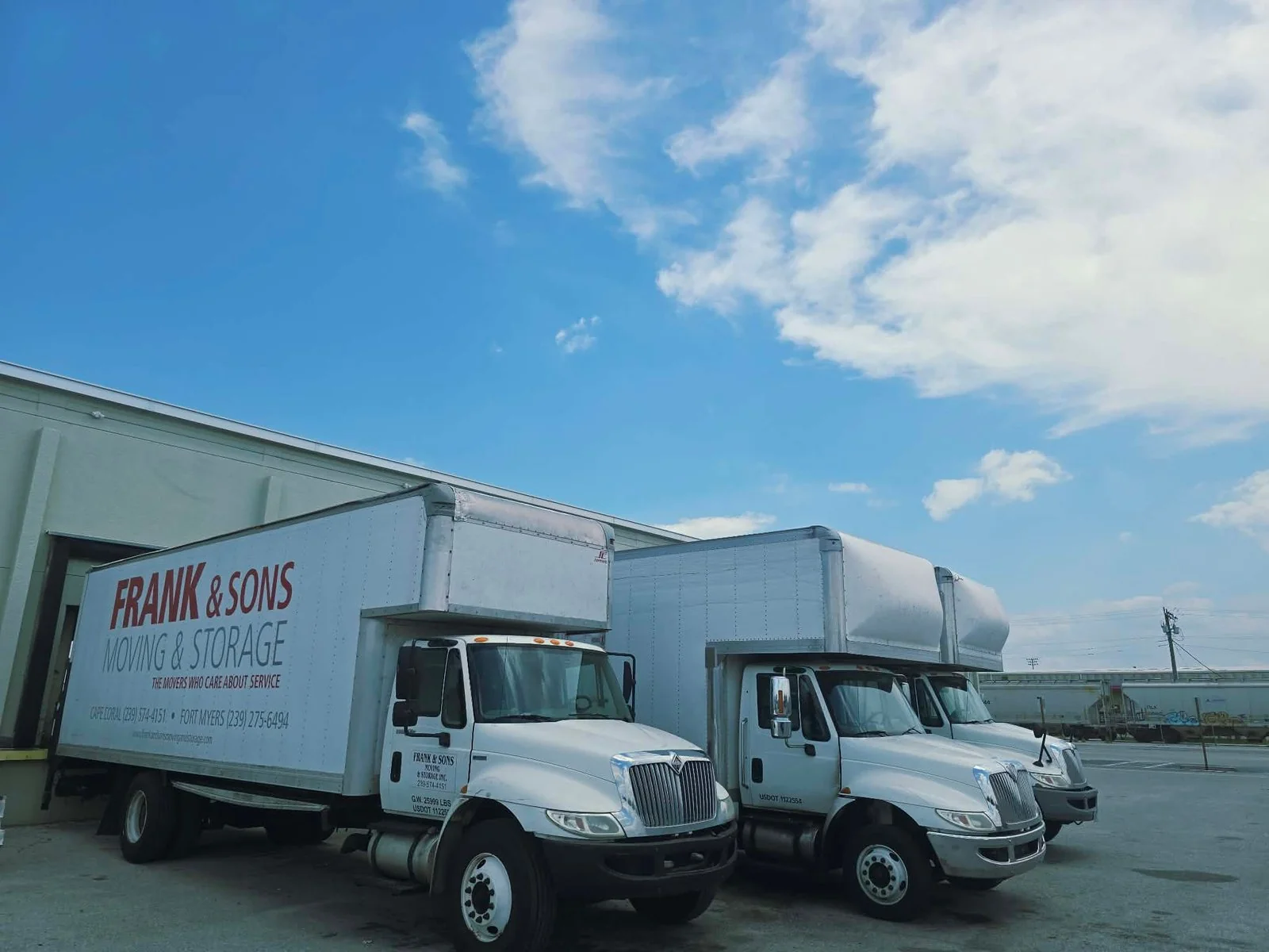Frank and Sons moving trucks beside the company warehouse