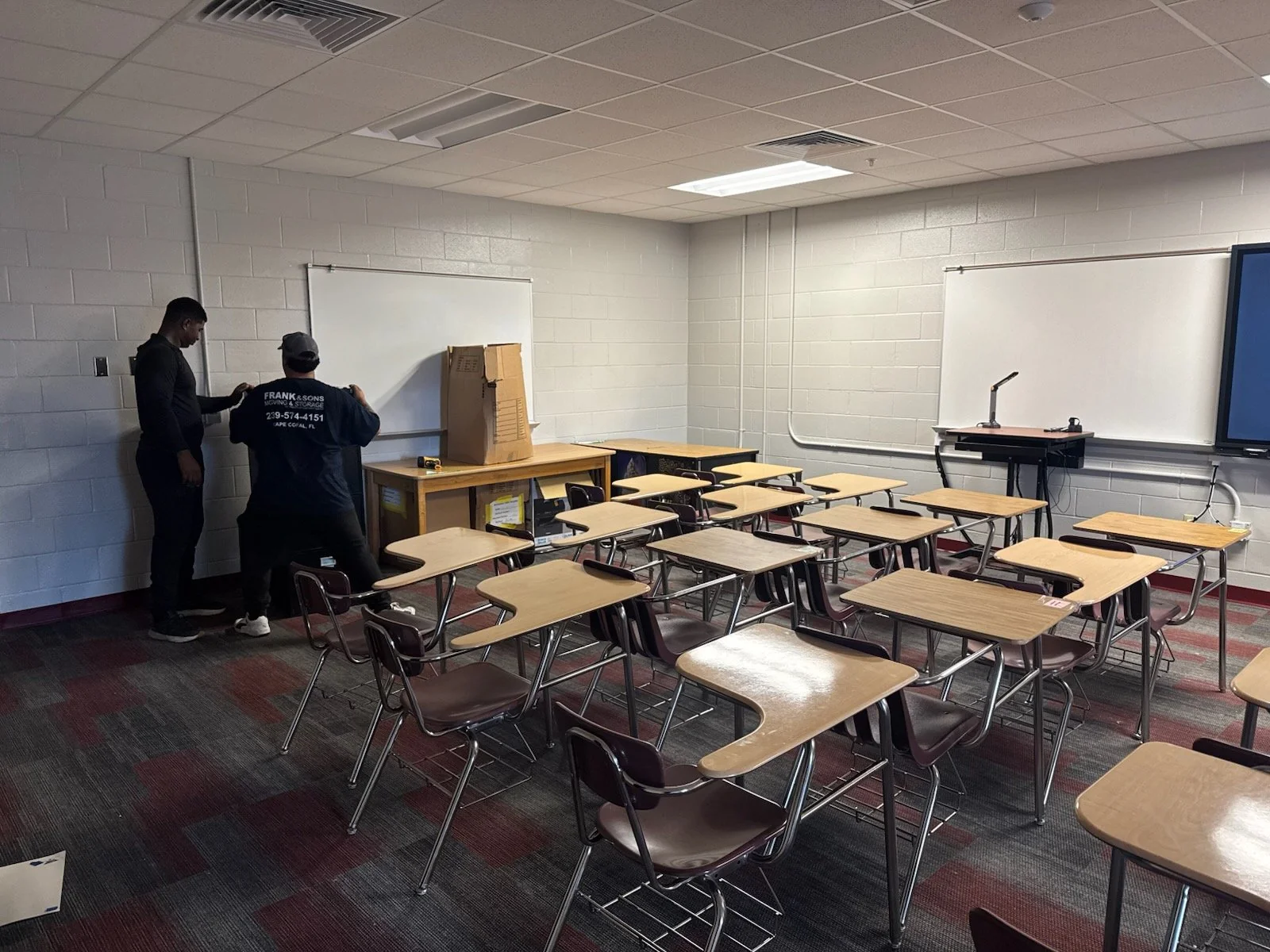 Frank and Sons crew members working beside desks in a classroom