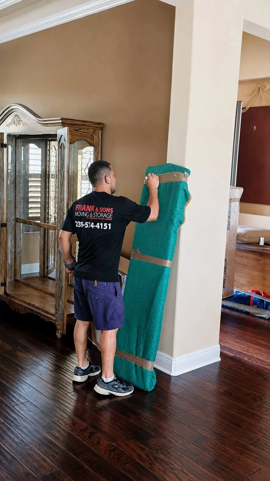 Frank and Sons crew member handling an item protected by a green moving blanket