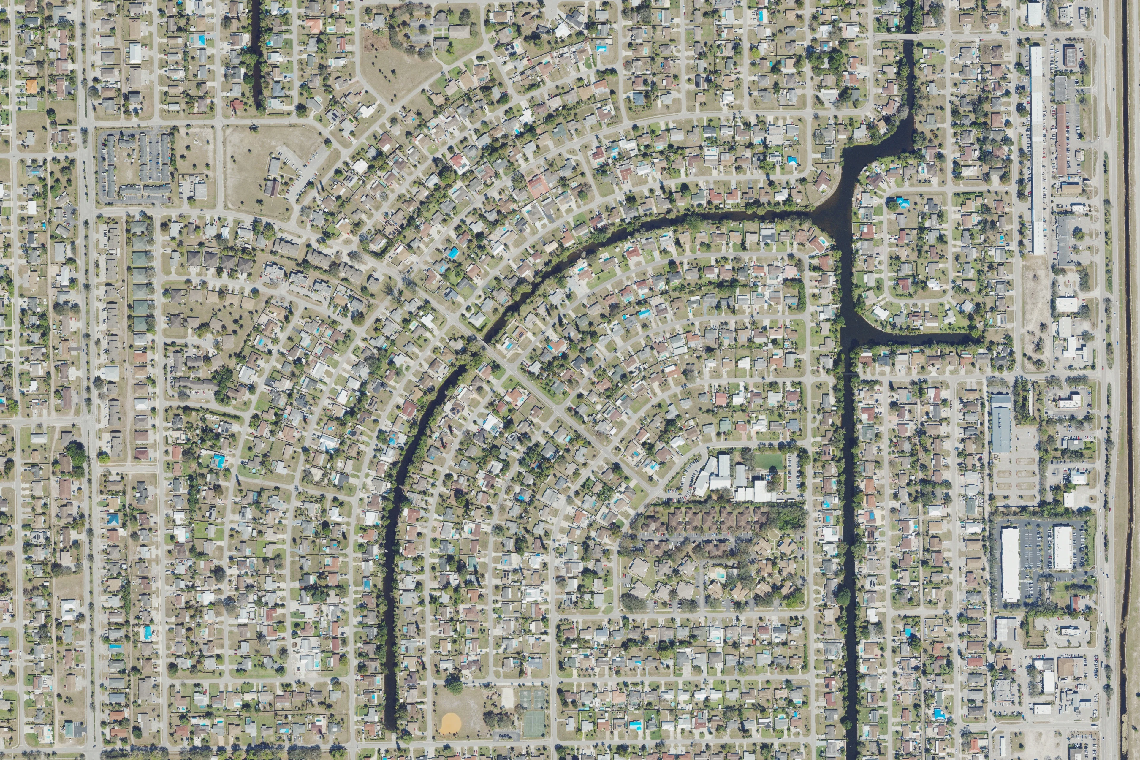 Aerial view of eastern Golden Gate City homes beside a curving canal