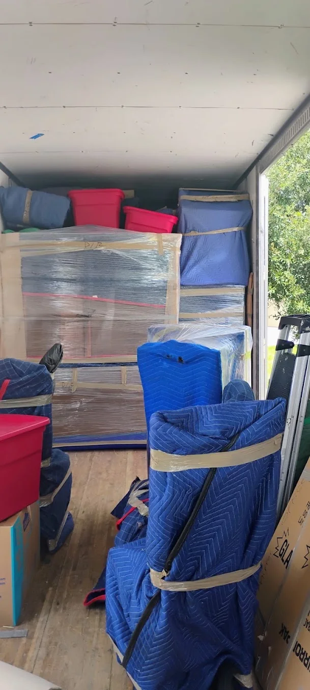 Furniture wrapped with moving blankets and stretch wrap inside a truck