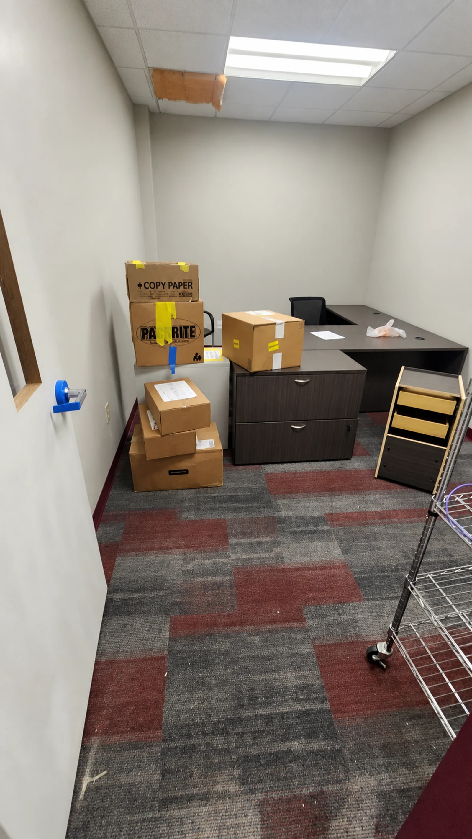 Moving cartons and filing drawers beside an office desk and chair