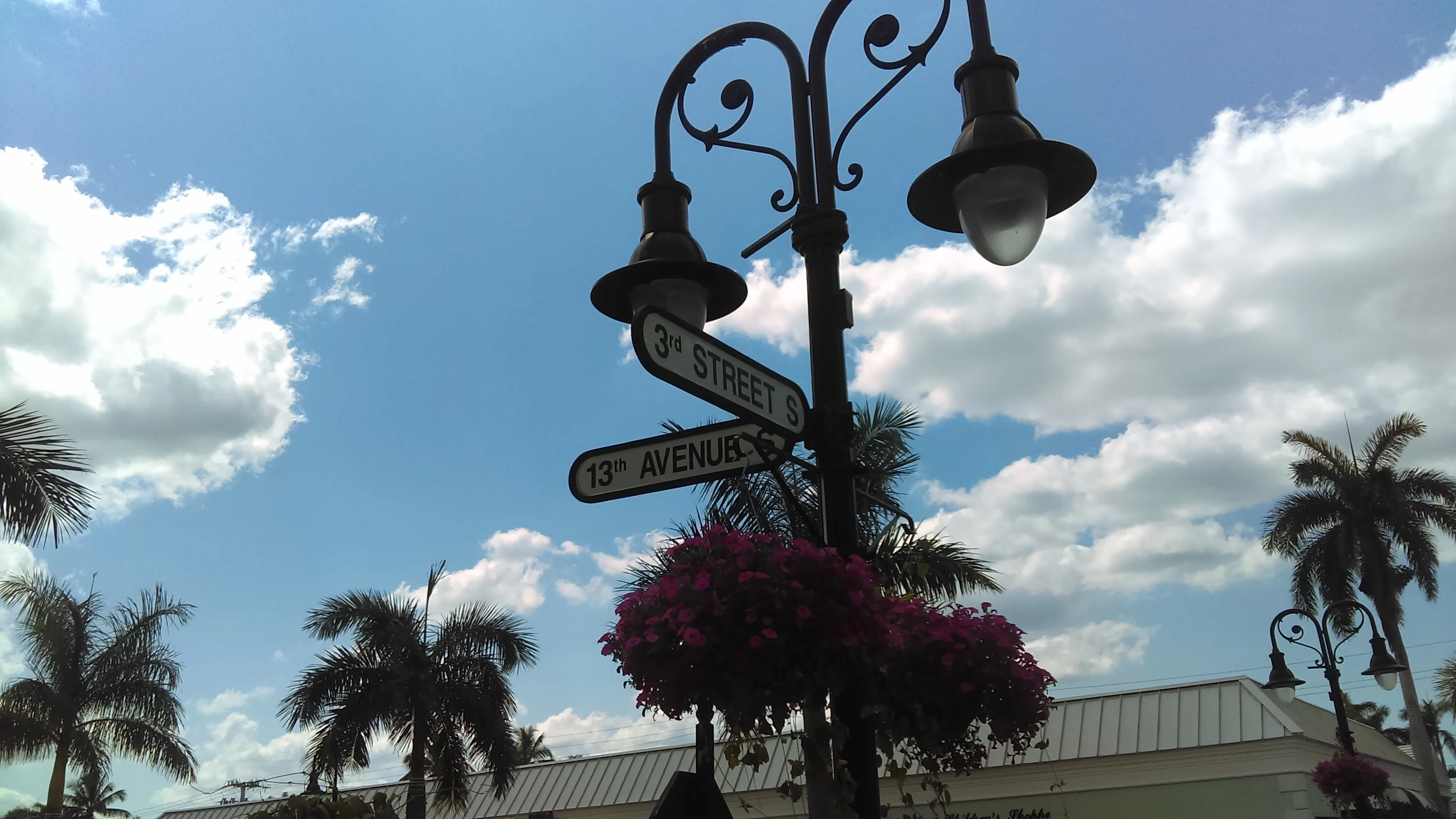 Flower basket and street signs at Third Street South and Thirteenth Avenue South in Old Naples
