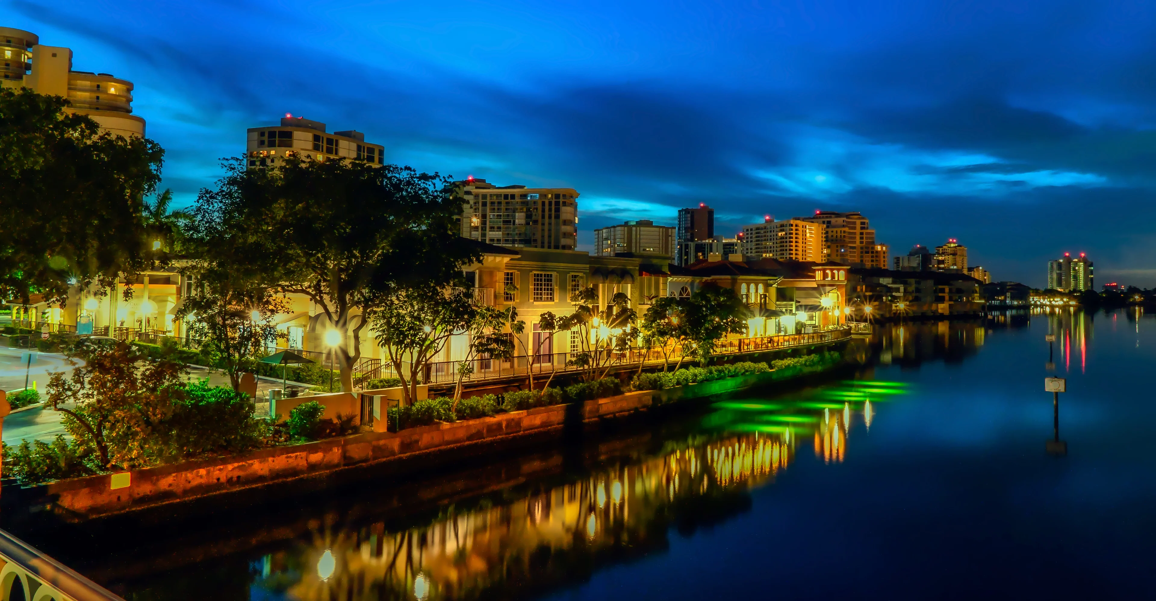 Waterfront buildings reflected in Venetian Bay at dusk in Park Shore