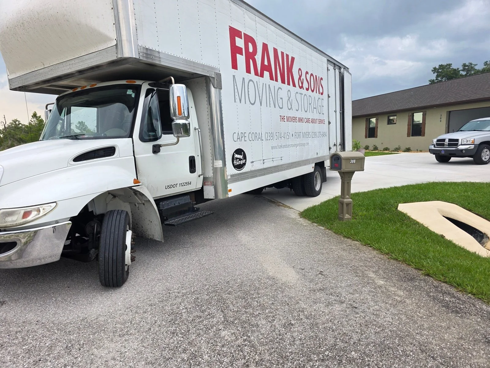 Frank and Sons moving truck parked on a curved driveway