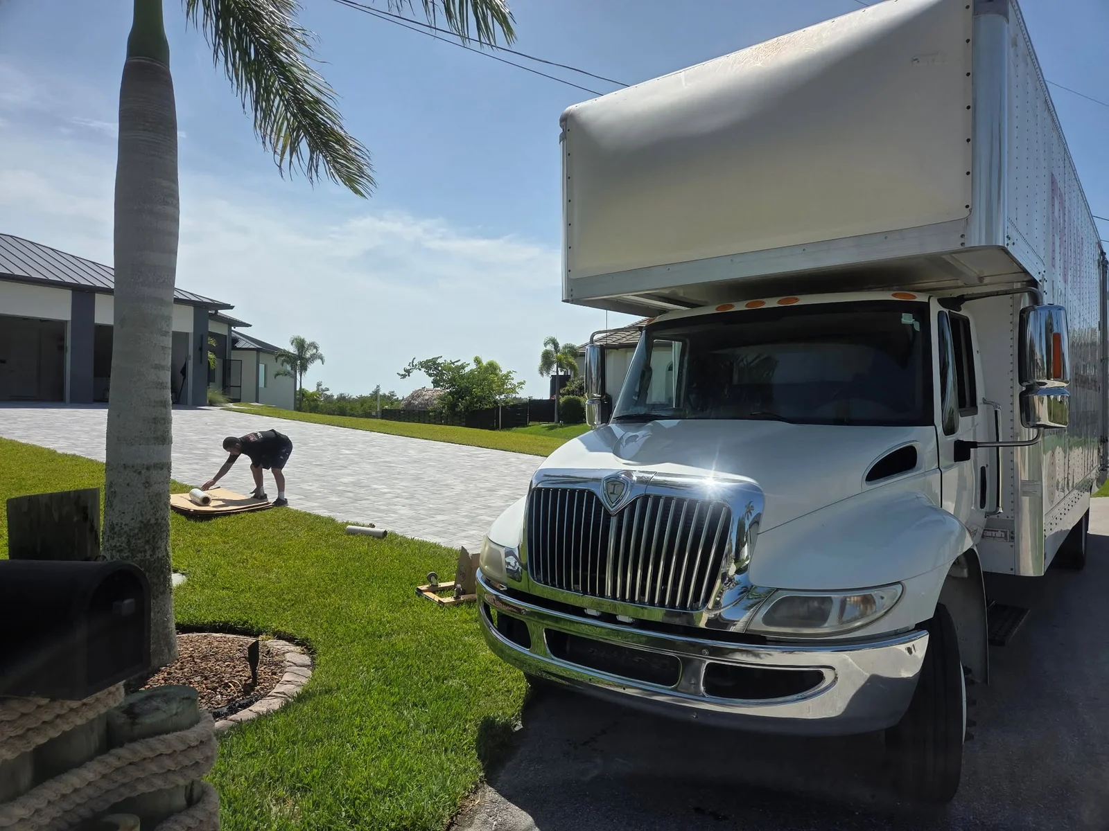 Moving truck and a crew member outside a home