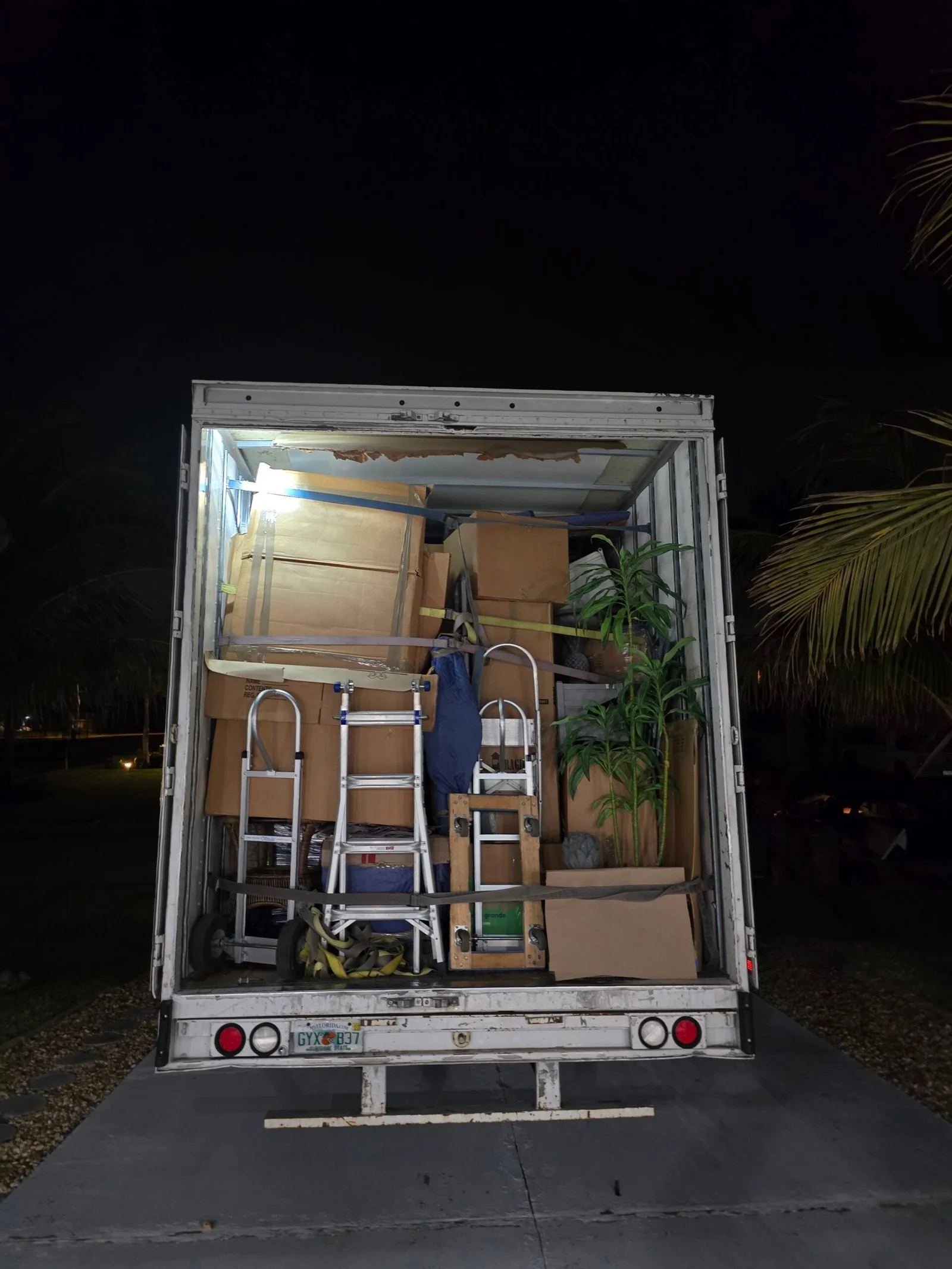 Furniture and moving equipment secured inside a truck at night