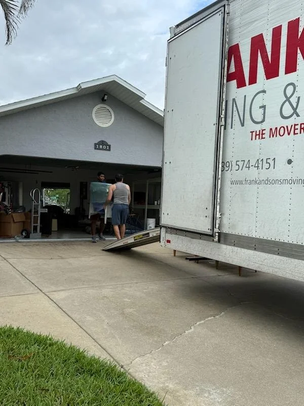 Frank and Sons moving truck beside an open residential garage