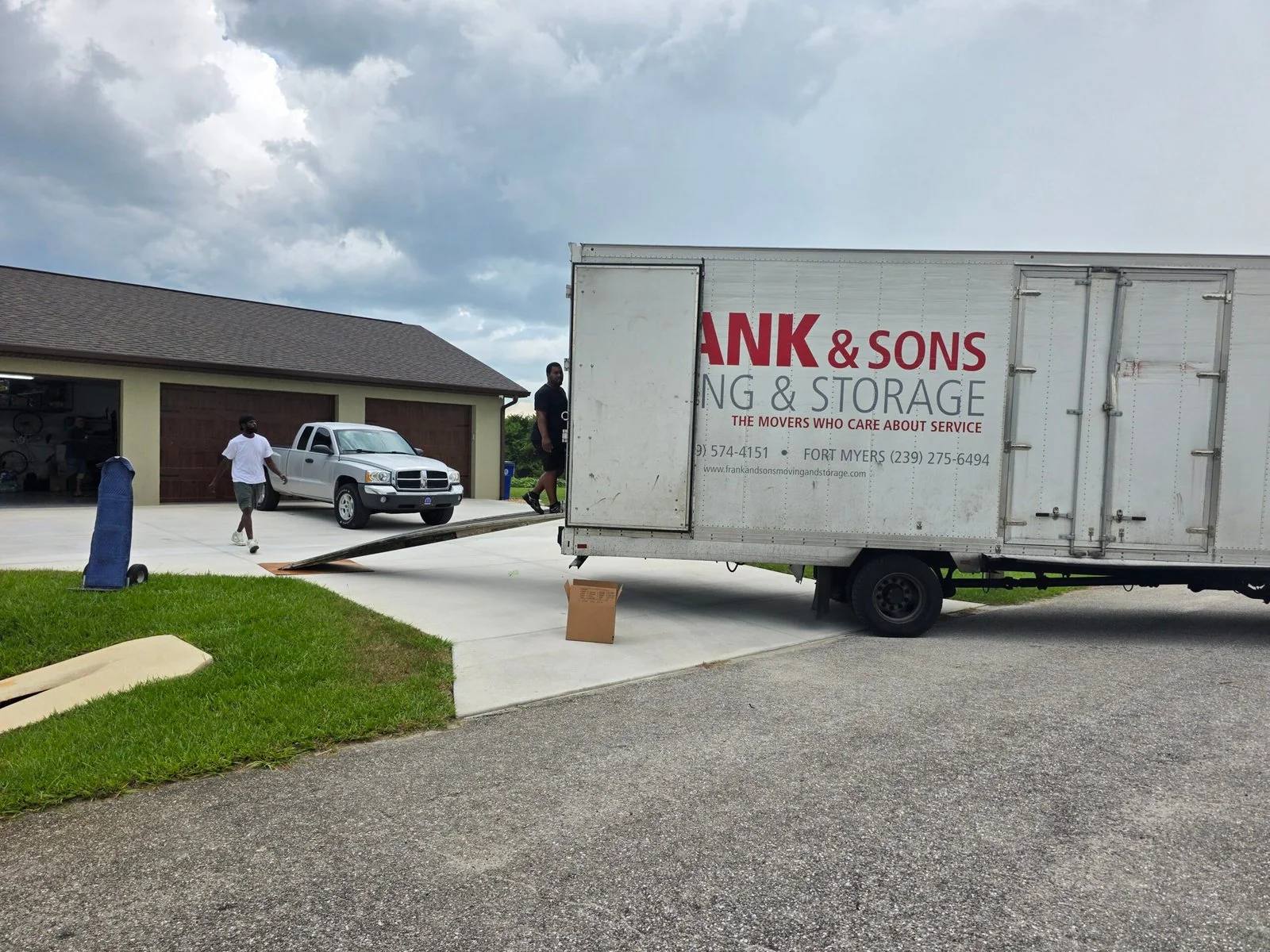 Frank and Sons moving truck beside a residential garage