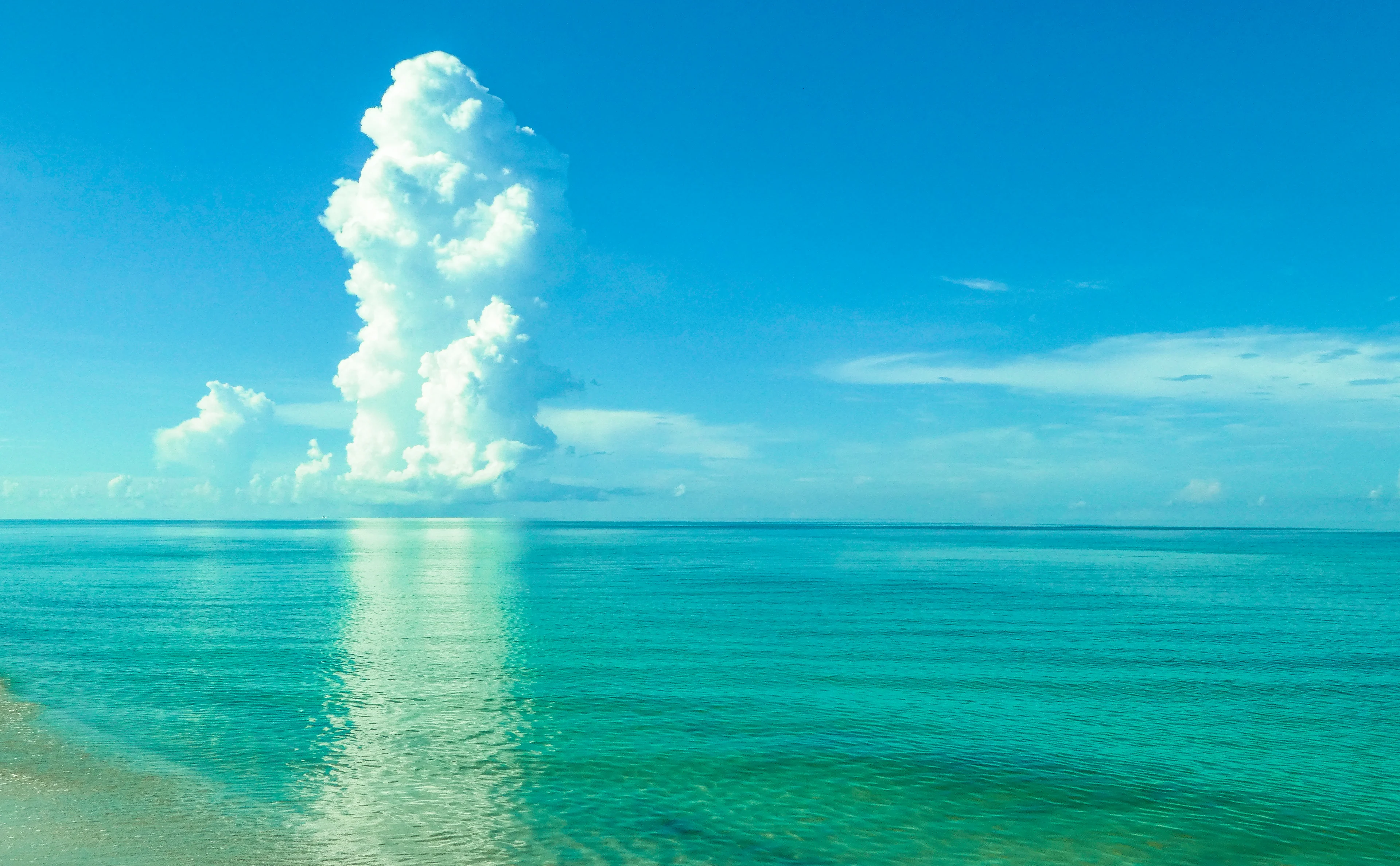 Clear Gulf water and a rising white cloud at Vanderbilt Beach in Naples