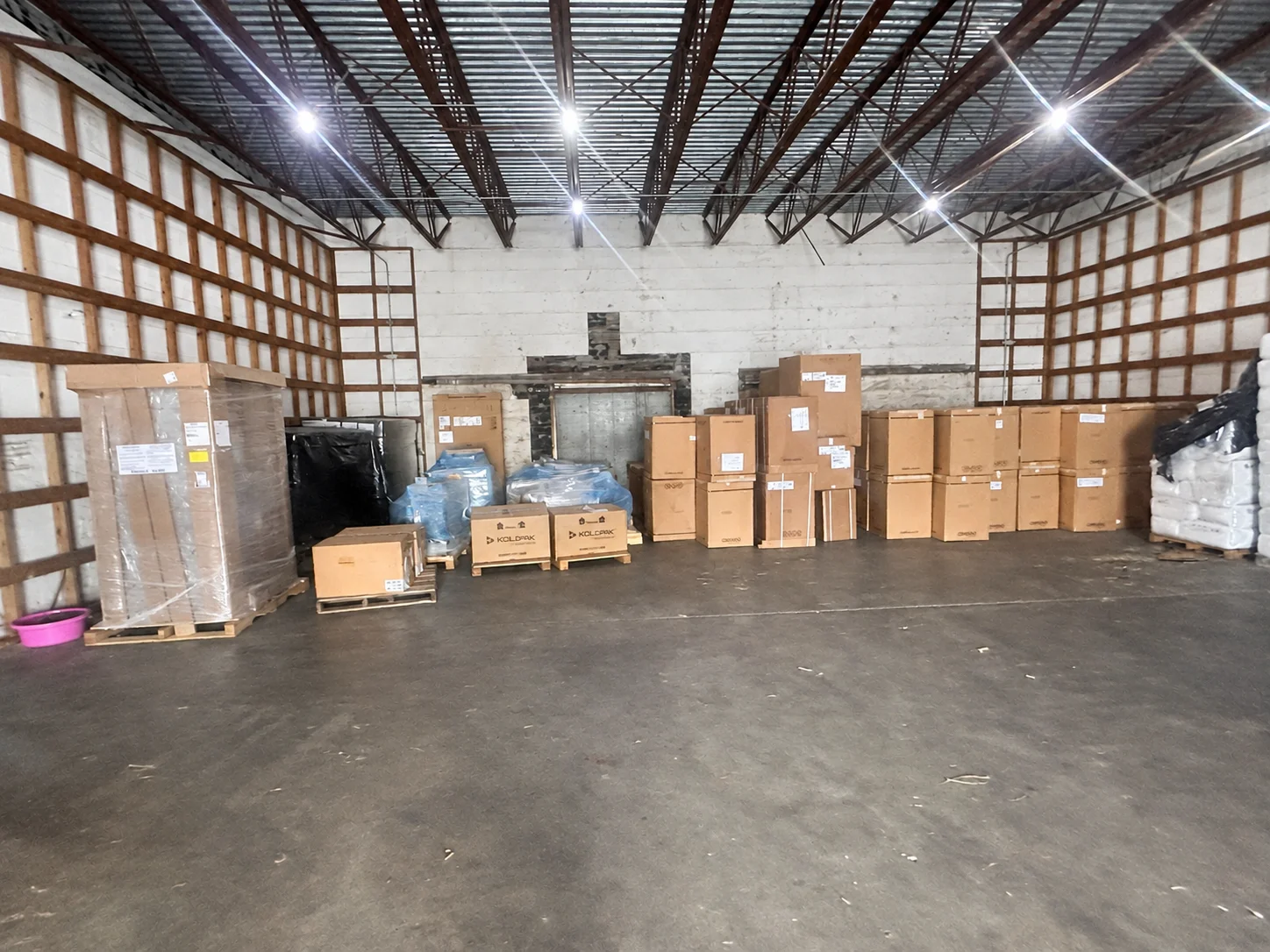 Boxed and wrapped items arranged on pallets inside a warehouse