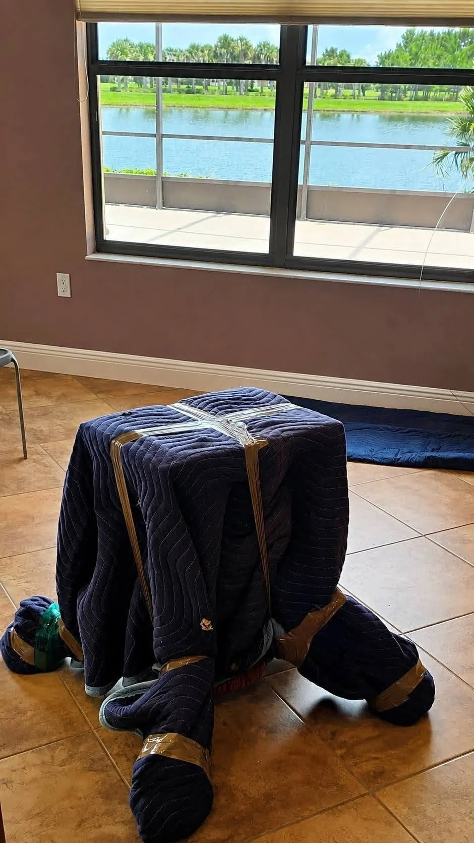 A blanket wrapped furniture piece in a home overlooking a lake